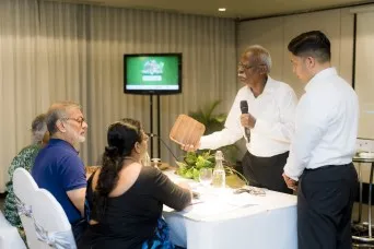 three individuals signing documents for promoting recycling initiatives